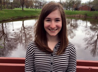 Graduate Student from HDFS standing in front of a lake and smiling
