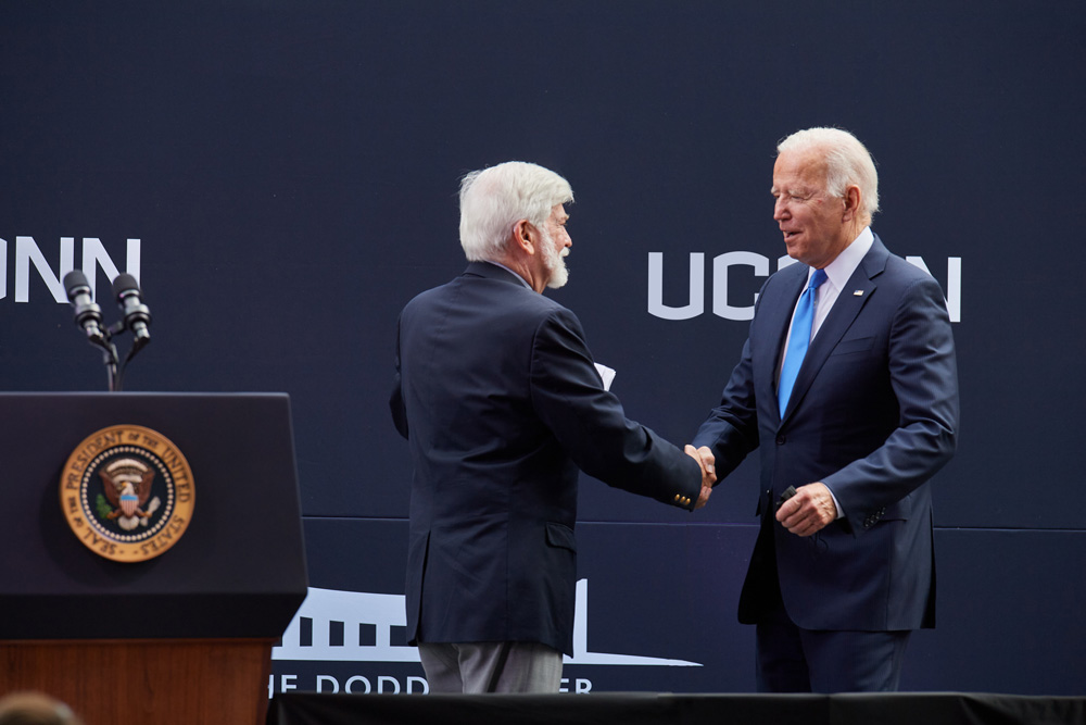 Former Senator Christopher J. Dodd, left, and President Joe Biden shake hands and hug onstage during the dedication ceremony of The Dodd Center for Human Rights at the University of Connecticut main campus in Storrs on Oct. 15, 2021. 