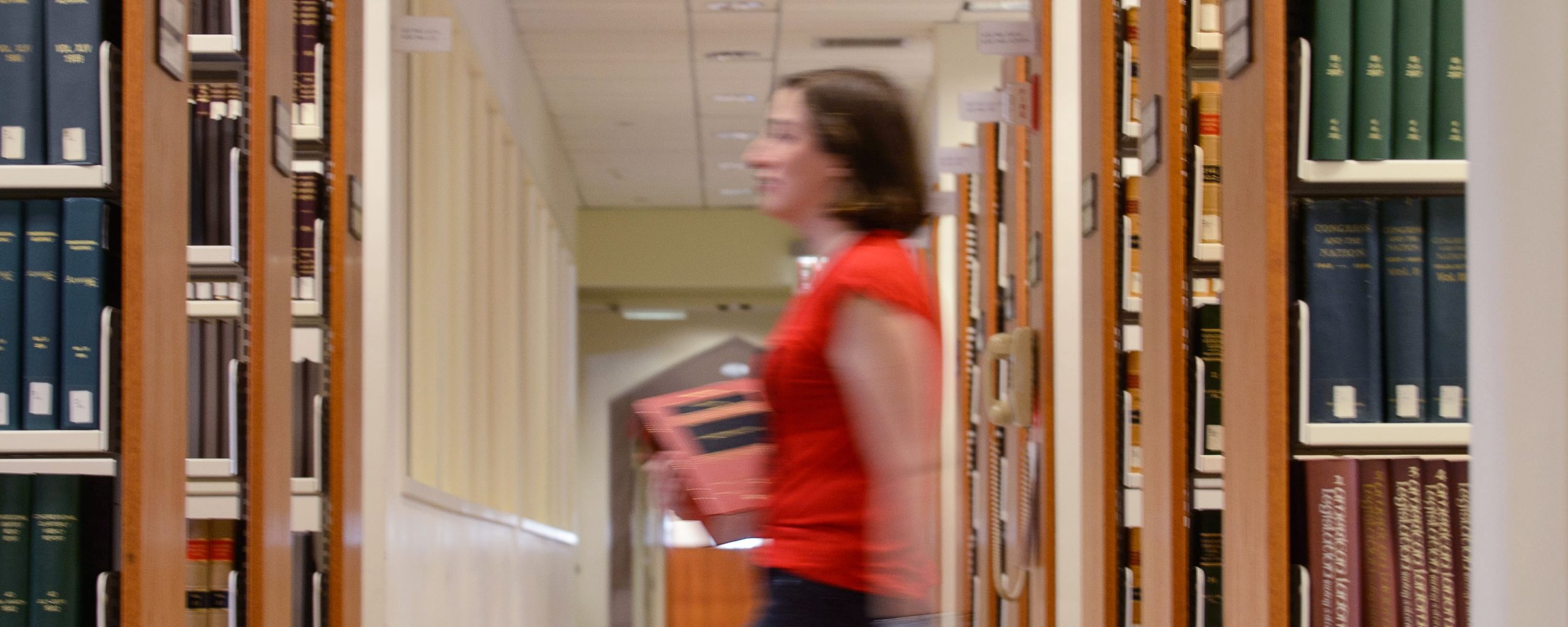 Student walks through the library stacks