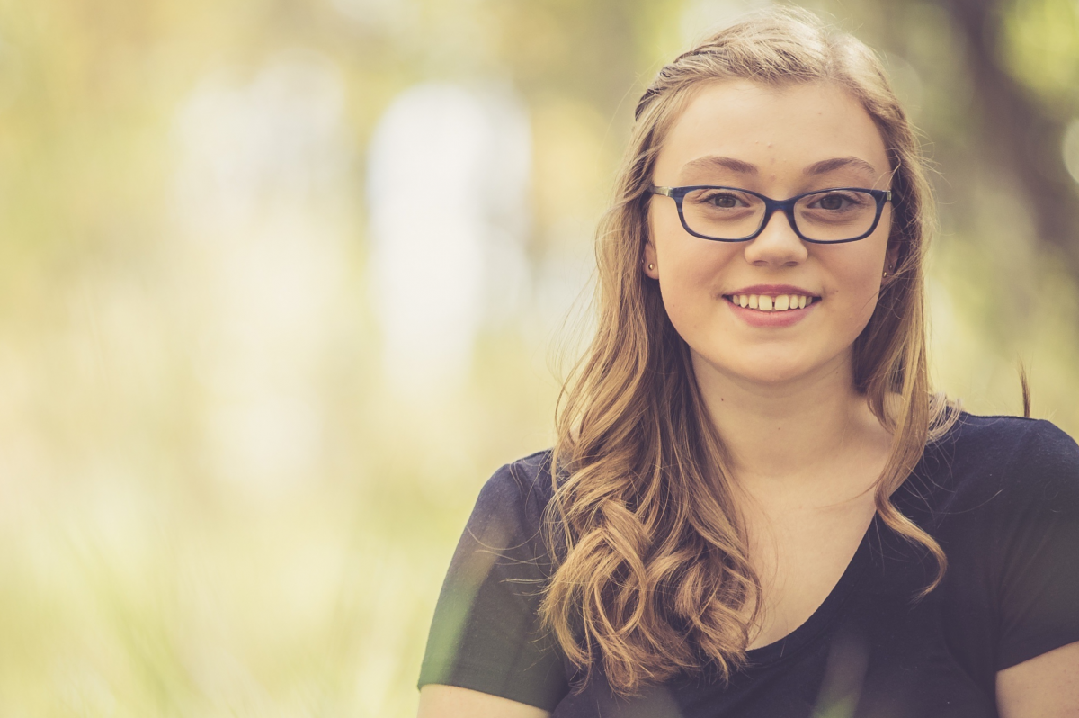 Sage Montana, a woman in a black shirt smiles at the camera.